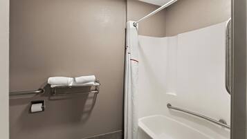 A bathroom with a bathtub, a shower curtain, and a towel rack with two towels.