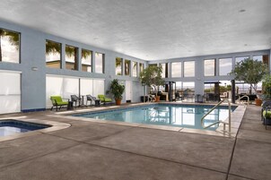 Una piscina techada, una piscina al aire libre, sombrillas