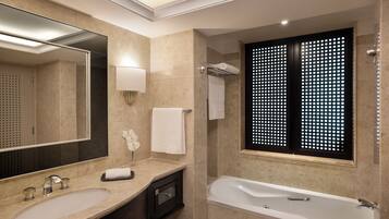Une salle de bain moderne avec un grand miroir, un lavabo, une baignoire et une fenêtre agrémentée d’un paravent décoratif.