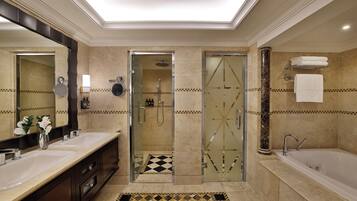A modern bathroom with two sinks, a glass-enclosed shower, and a separate bathtub.
