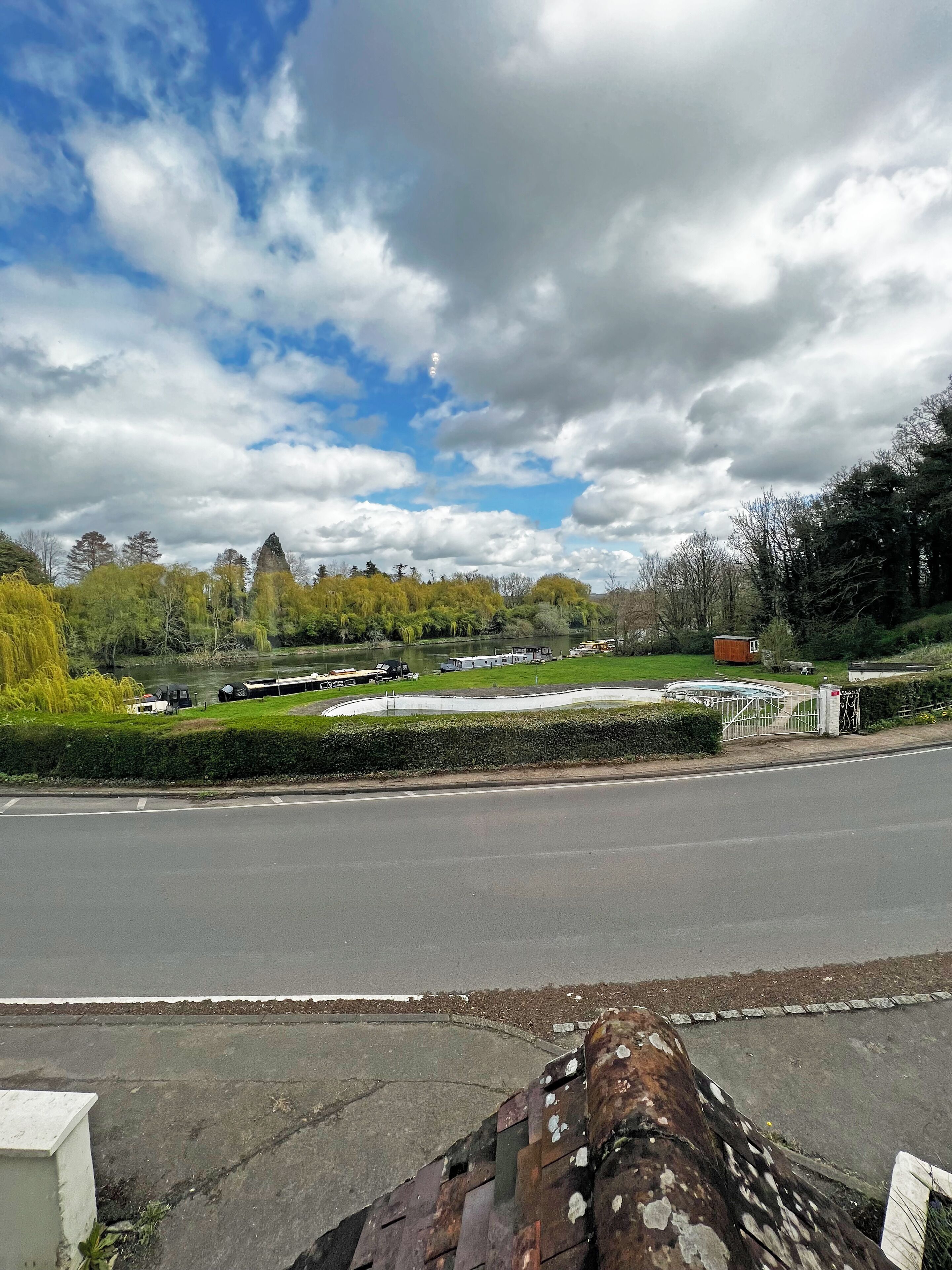 A road with a curved path and a fenced area with a building.