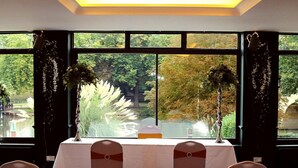 A banquet hall with a long table, white tablecloth, and chairs with white covers. - Shillingford Bridge Hotel (Wallingford)