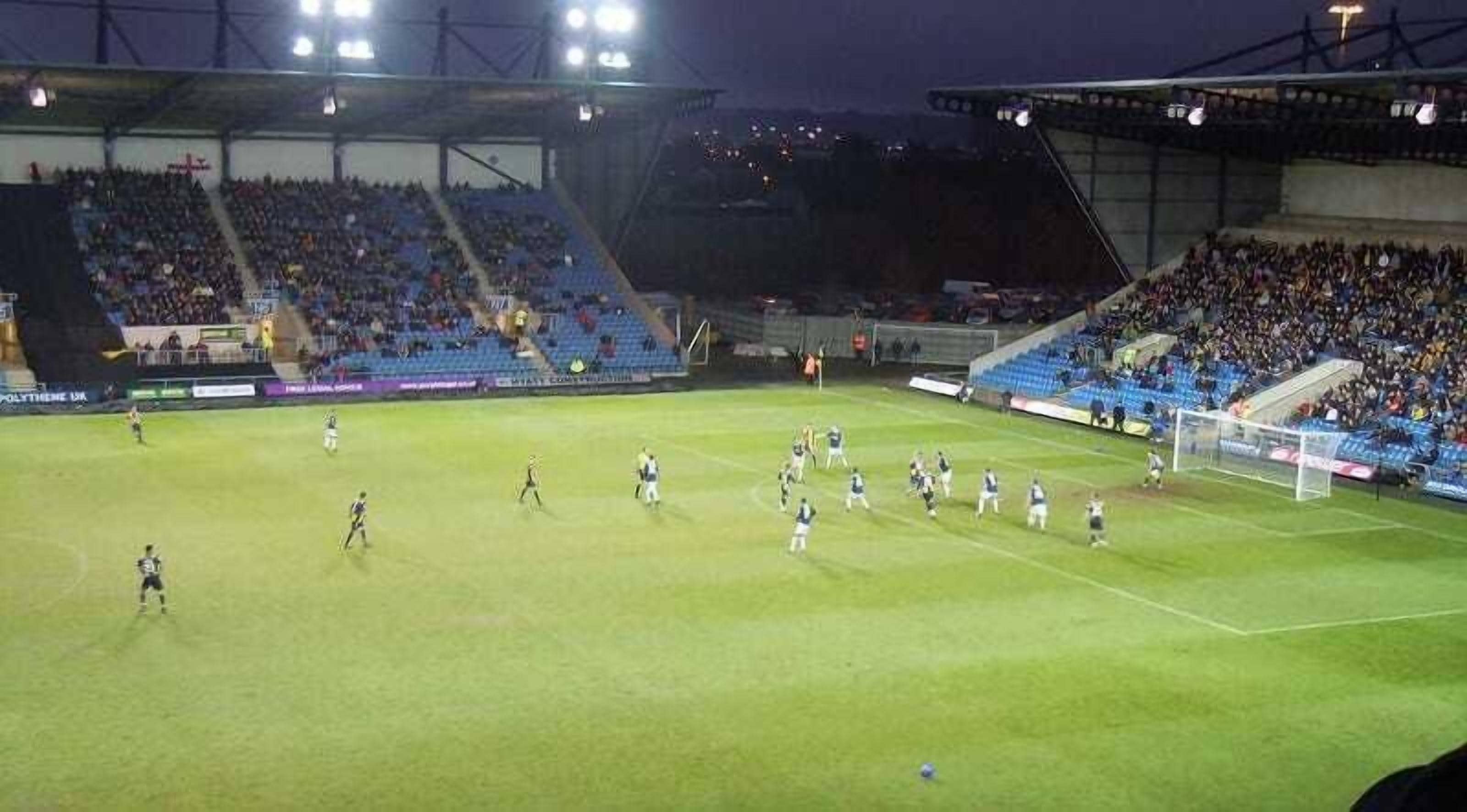 A stadium with multiple tiers of seating and a well-lit field.