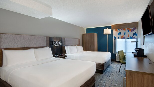 A hotel room with two beds, a desk, a chair, a TV, and a patterned wall. - Holiday Inn Express Rochester - University Area by IHG (Rochester)