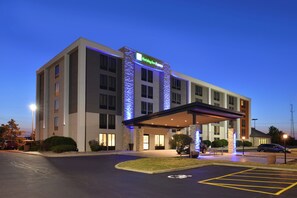 A Holiday Inn Express hotel with a covered entrance, parking lot, and a clear sky. - Holiday Inn Express Rochester - University Area by IHG (Rochester)