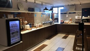 A breakfast area with a digital menu display, a cereal section, and a bakery. - Holiday Inn Express Rochester - University Area by IHG (Rochester)