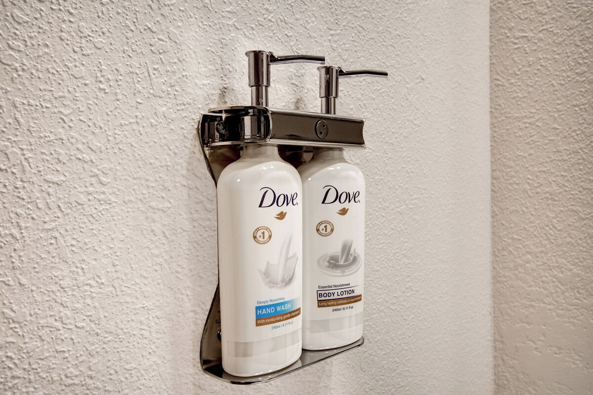 Two Dove hand wash bottles mounted on a wall.