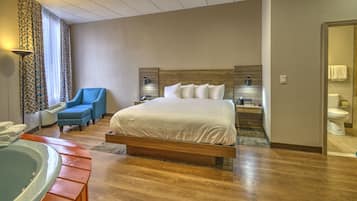Relax in a spacious room with a large bed, seating area, and hot tub.