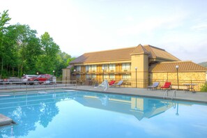 Piscine extérieure en saison, parasols, chaises longues