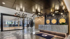 A modern reception area with a marble counter, geometric patterned floor, and contemporary lighting fixtures.
