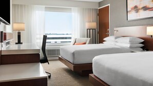A hotel room with two beds, a desk, a chair, and a large window with curtains. - Delta Hotels by Marriott Indianapolis Airport (Indianapolis)