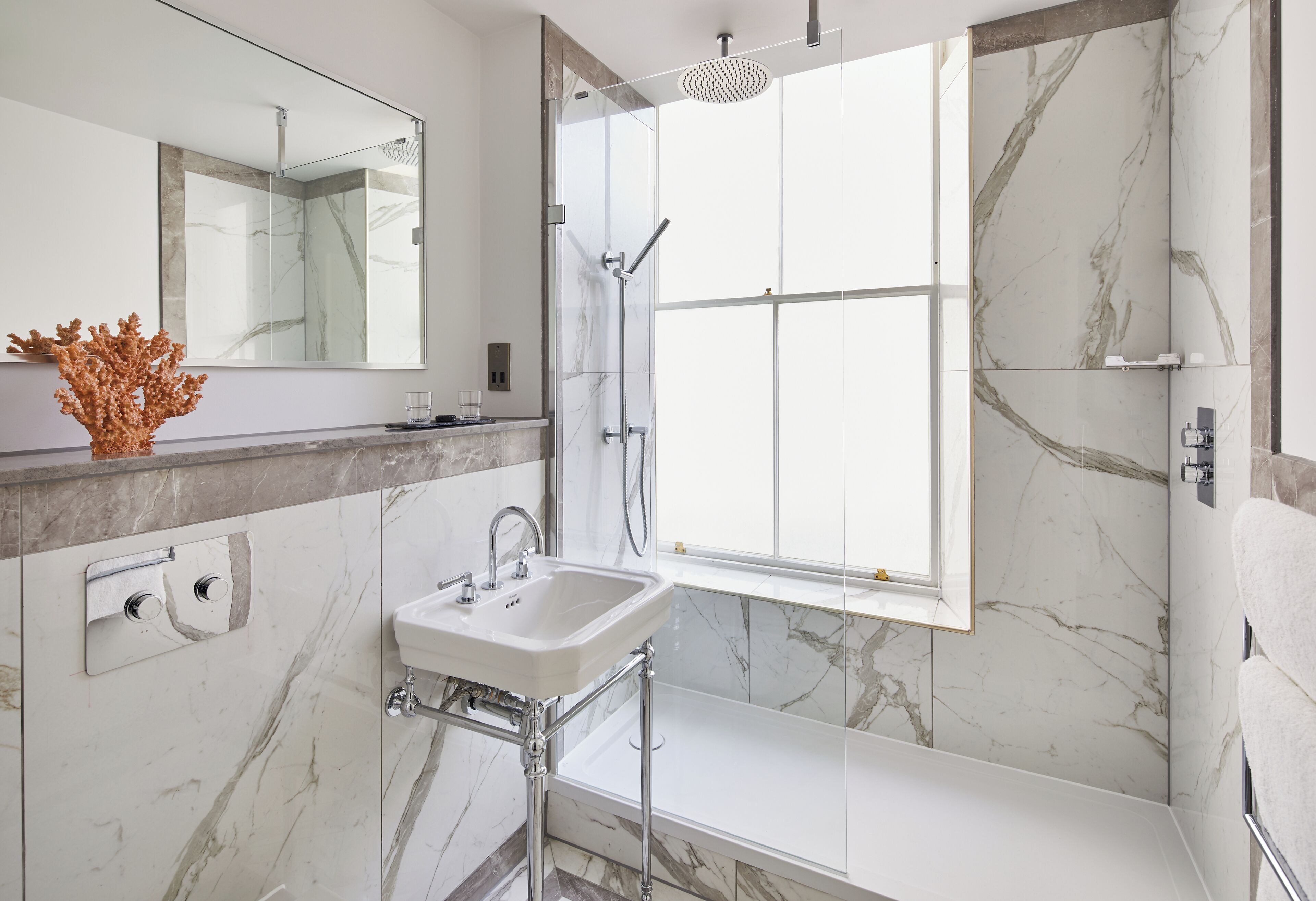 A modern bathroom with a large mirror, a sink, a shower, and a bathtub.