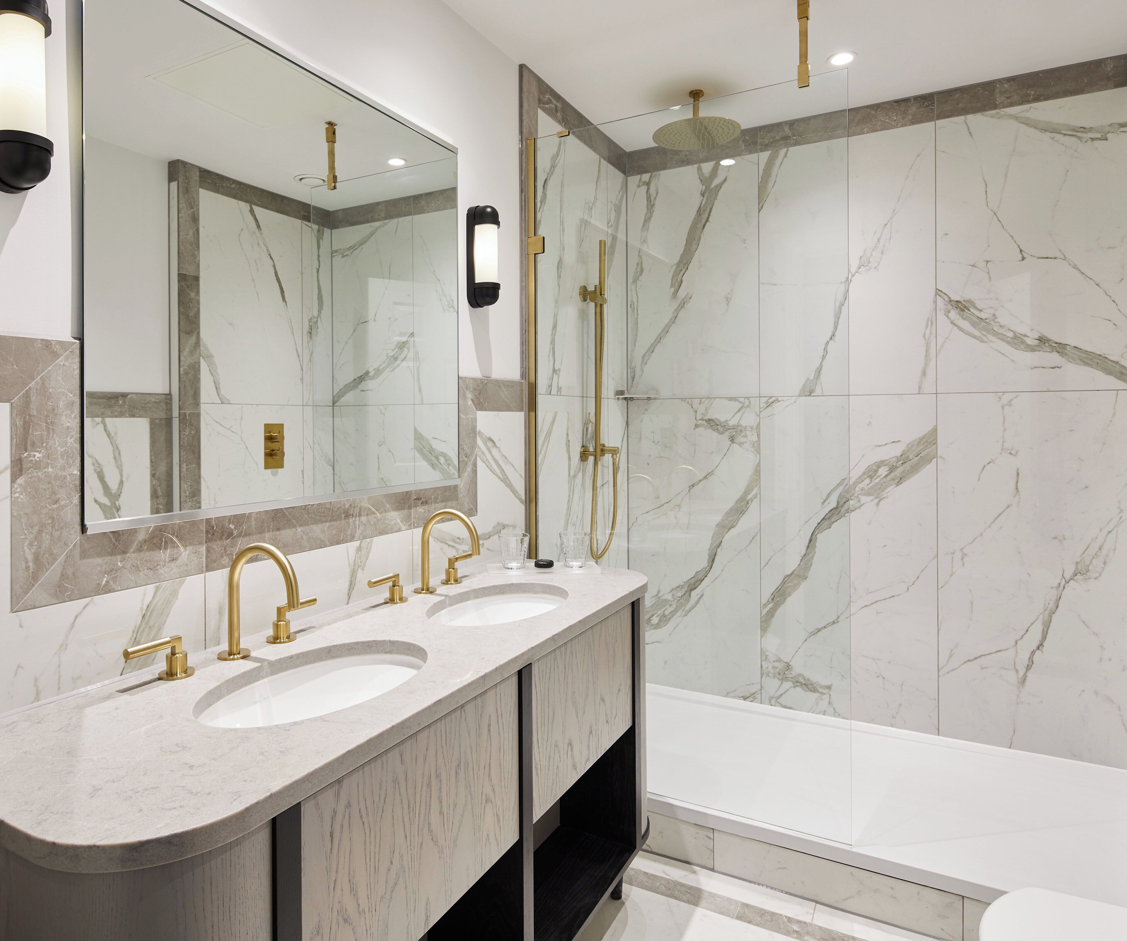 Un baño moderno con dos lavamanos, un espejo grande y una zona de ducha.