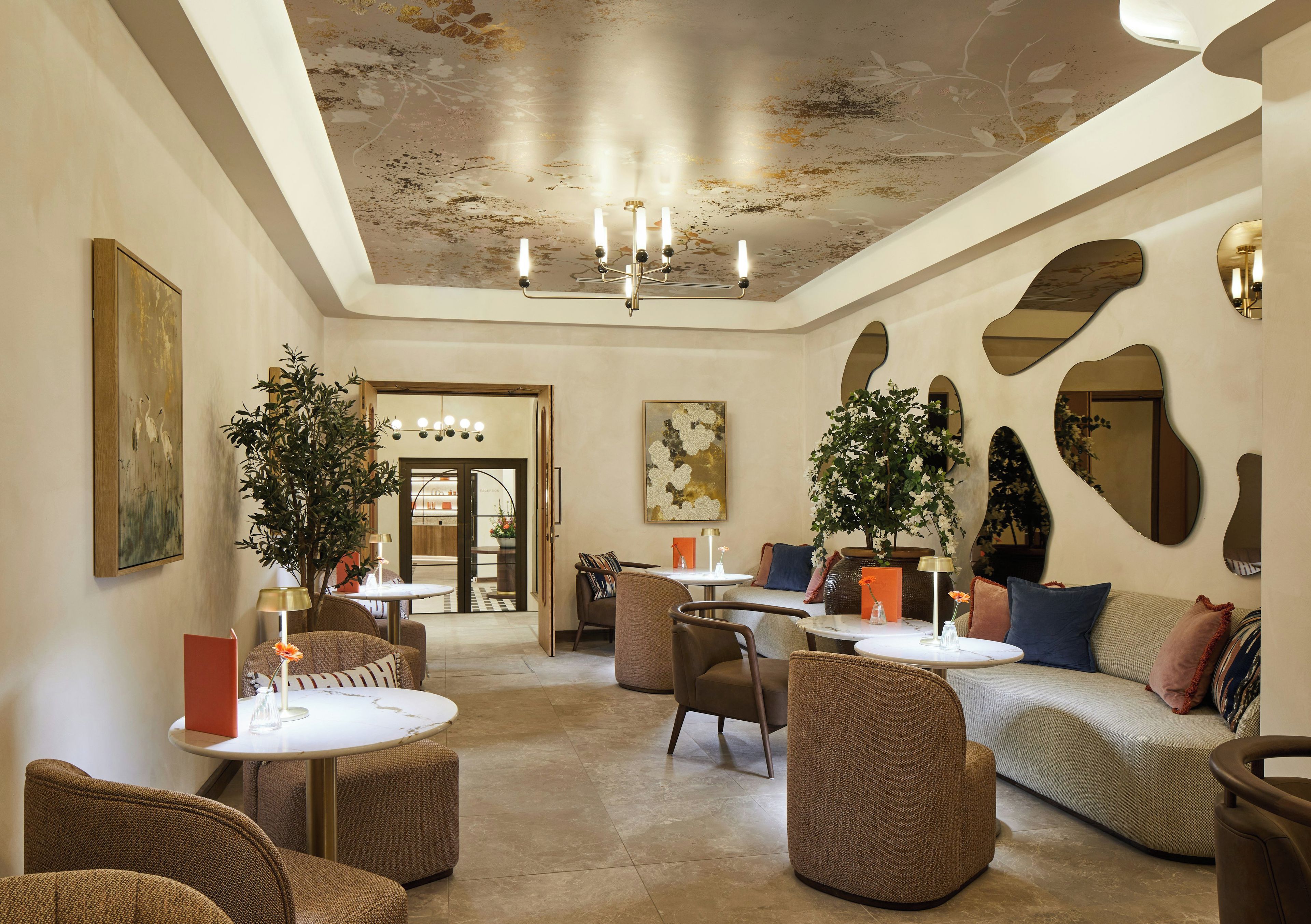 A spacious lounge area with multiple seating options, including sofas and chairs, a coffee table, and a chandelier.