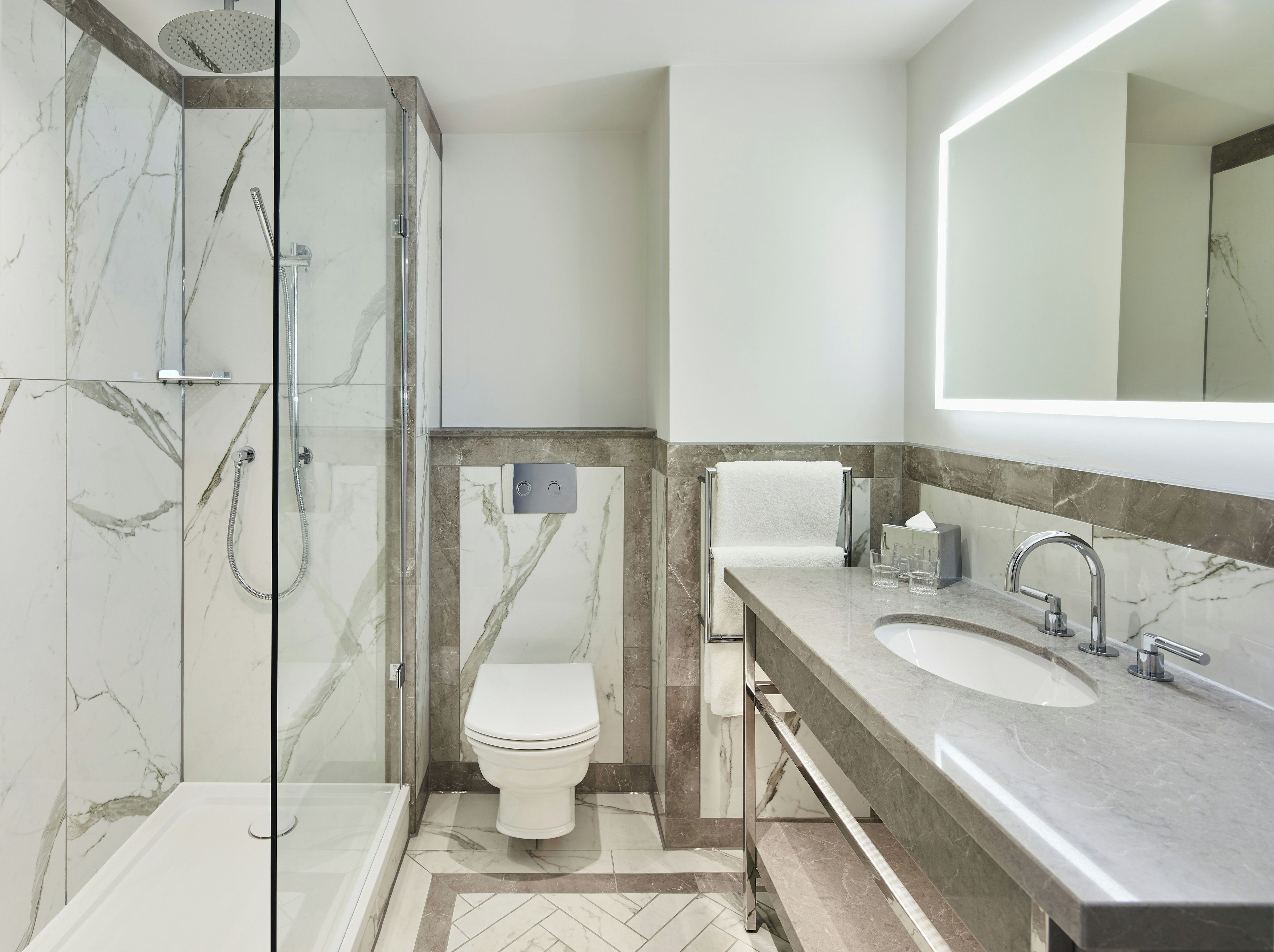 A modern bathroom with a glass-enclosed shower, a toilet, and a vanity with a sink.