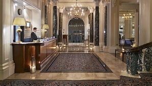 A grand lobby with marble columns, a chandelier, and a reception desk. - The Grand Brighton (Brighton)