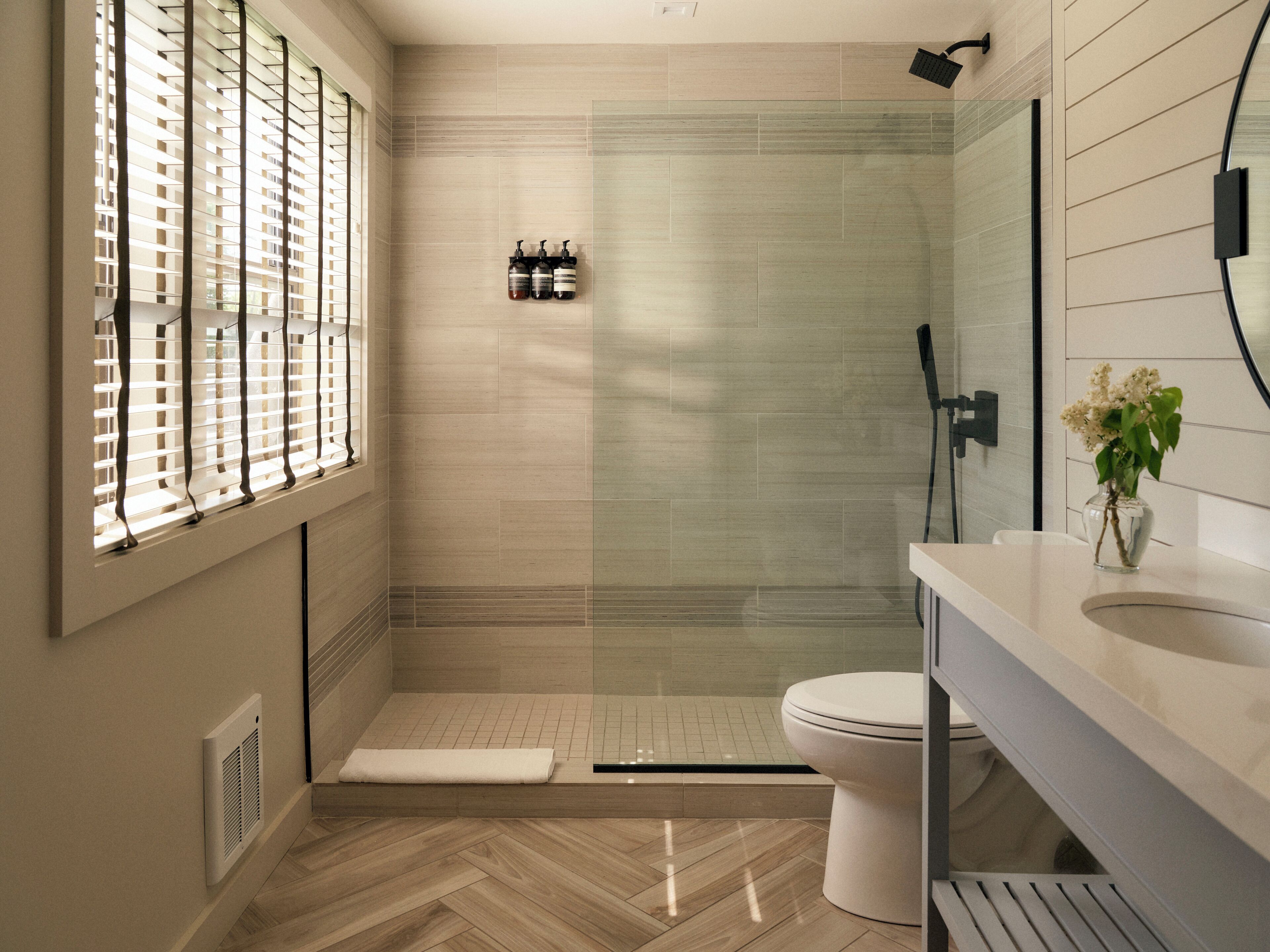 Un baño moderno con ducha, inodoro y lavamanos.