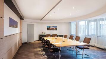 A conference room with a long table, chairs, and a whiteboard.