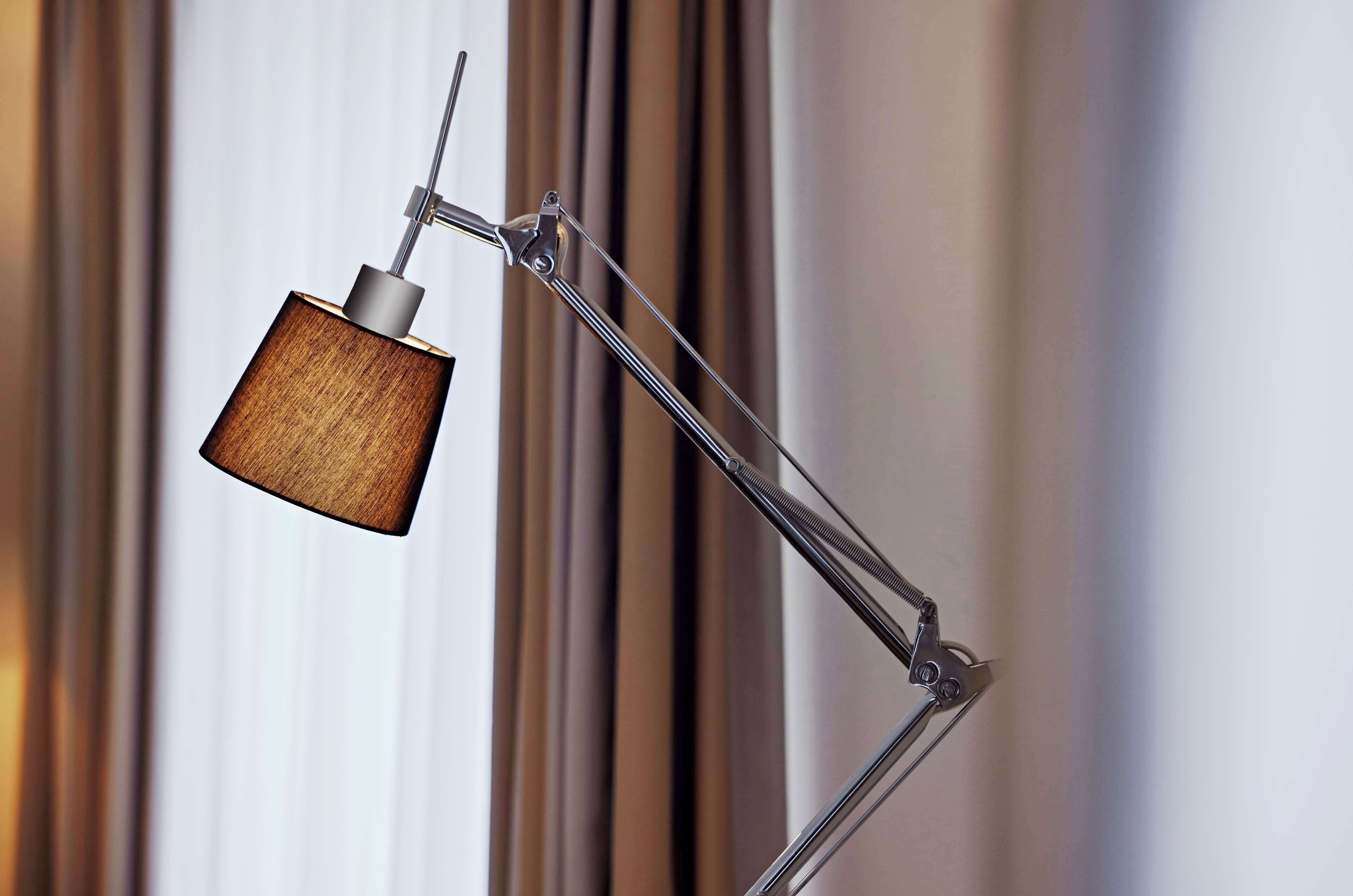 Una lámpara de escritorio moderna con pantalla de madera y pie metálico.