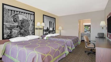 Una habitación de hotel con dos camas, un escritorio con computadora y televisión.
