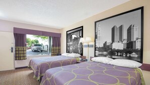 A hotel room with two beds, a cityscape view, a window with curtains, and a lamp.
