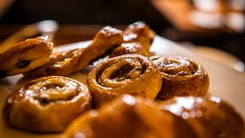 Primer plano de rollos de canela con almíbar en un plato.