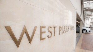 Un letrero de hotel con el nombre 'WEST PLAZA HOTEL' en letras grandes y negritas.