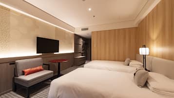 A hotel room with two beds, a sofa, a TV, and a small table.