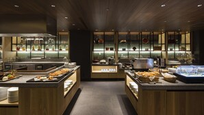 Una cucina moderna con mobili in legno, elettrodomestici in acciaio inossidabile e un'area buffet con diverse pietanze.