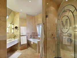 Ein modernes Badezimmer mit Duschkabine aus Glas, einer Badewanne und einem Waschtisch mit Waschbecken und Spiegel.