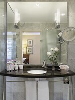 Un bagno moderno con uno specchio grande, un lavandino e articoli da toilette.