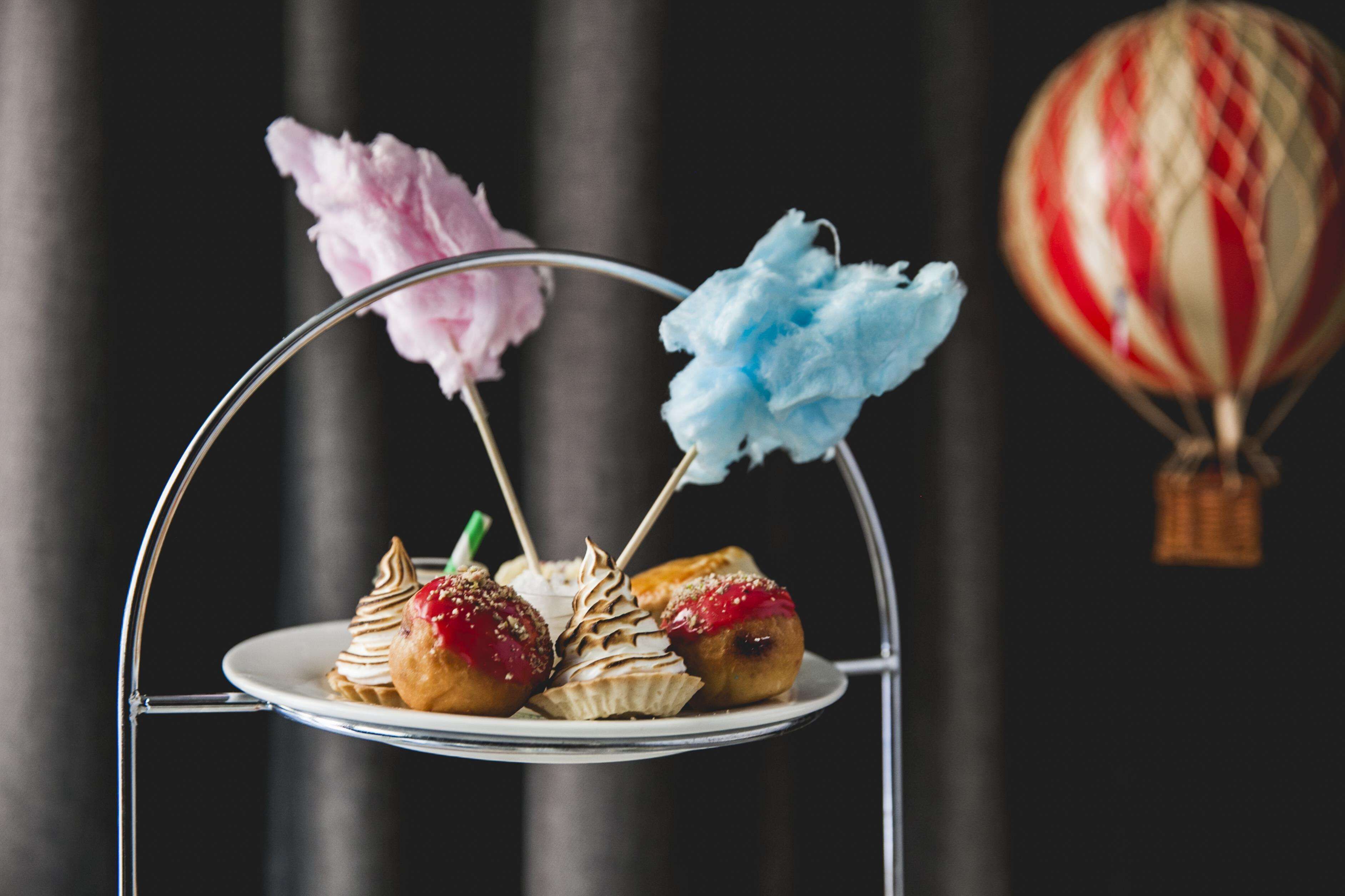 Un stand de desserts proposant diverses pâtisseries et de la barbe à papa.