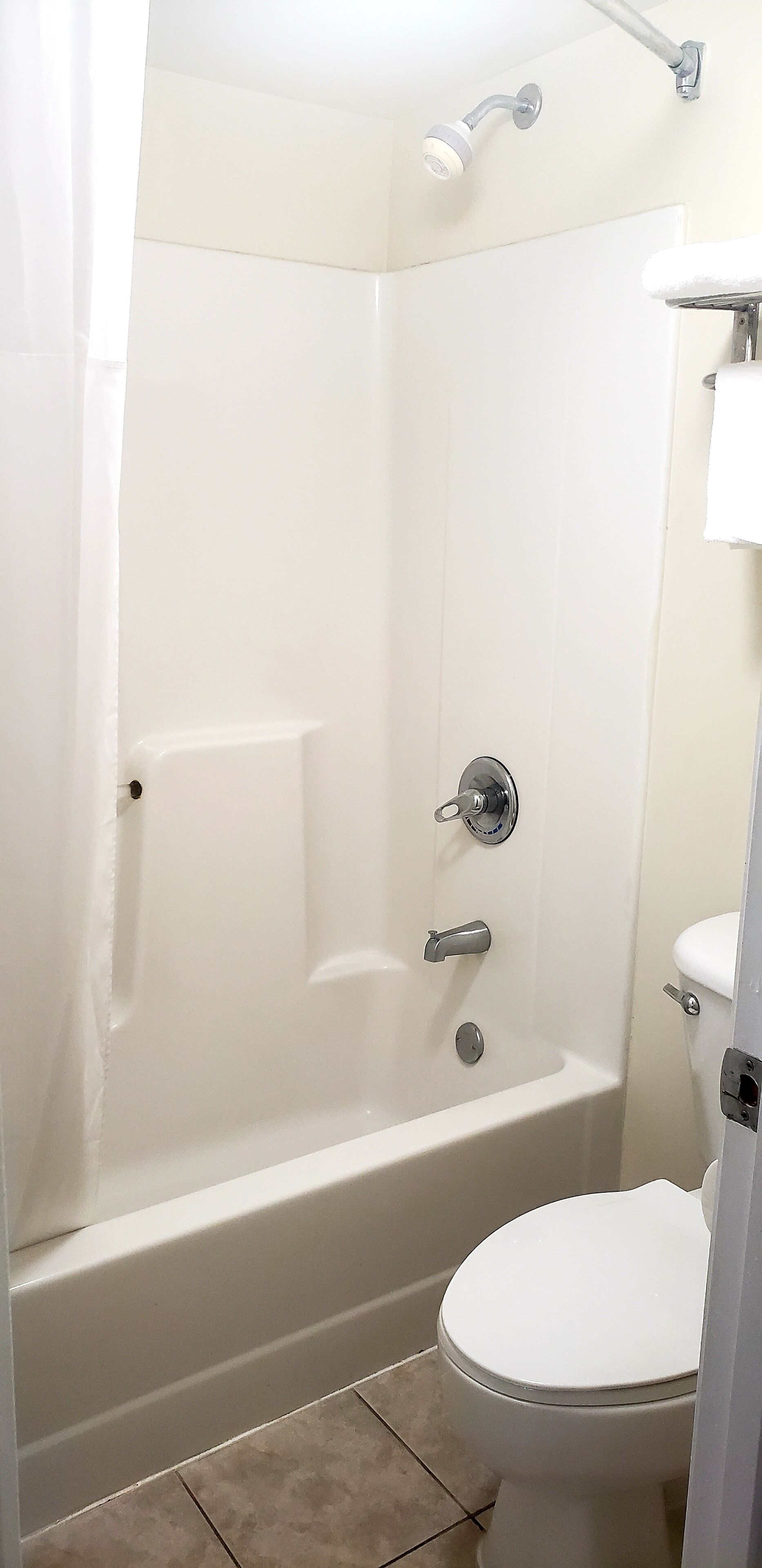 A bathroom with a bathtub, toilet, and shower.