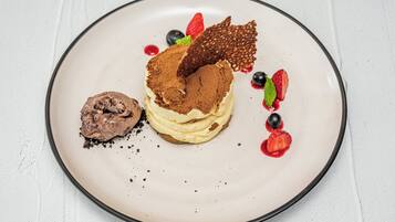 Ein Dessertteller mit einer mehrschichtigen Torte, Schokoladeneis und Beeren.
