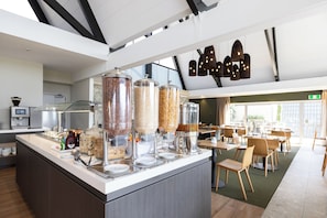 A self-serve breakfast station with various food containers and a coffee machine. - Auckland Rose Park Hotel (Auckland)