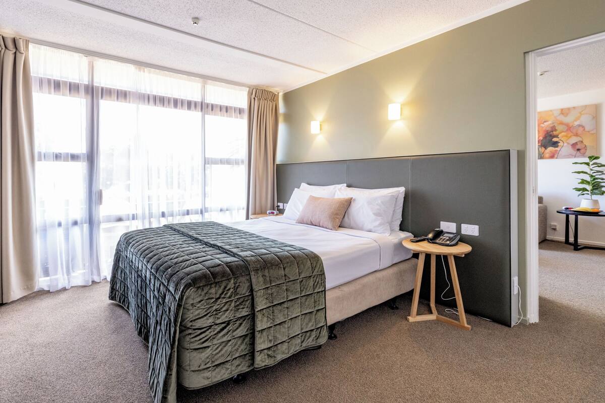 Junior King Suite with Lounge | Desk, laptop workspace, blackout drapes, iron/ironing board
