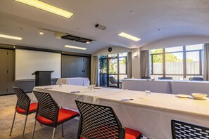 A conference room with a long table, chairs, a podium, and a large window. - Auckland Rose Park Hotel (Auckland)
