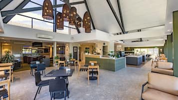 Amplio espacio interior con techos altos, varios conjuntos de asientos y una zona de bar central.