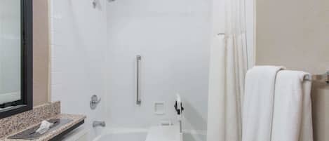 A modern bathroom with a walk-in shower, a bathtub, and a vanity with a mirror.