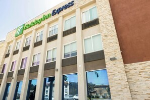 A Holiday Inn Express building with a modern facade, large windows, and a prominent signage. - Holiday Inn Express Anaheim West by IHG (Anaheim)