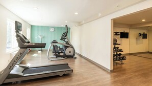 A home gym with a treadmill, elliptical, and dumbbells. - Holiday Inn Express Anaheim West by IHG (Anaheim)