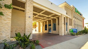 A hotel entrance with a covered walkway, stone facade, and a sign indicating it's a Holiday Inn Express. - Holiday Inn Express Anaheim West by IHG (Anaheim)