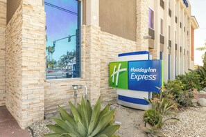 A Holiday Inn Express building with a stone facade, a large window, and a signboard. - Holiday Inn Express Anaheim West by IHG (Anaheim)