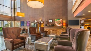 A spacious lobby with leather armchairs, a patterned rug, and a large metal coffee table. - Best Western Plus Scottsdale Thunderbird Suites (Scottsdale)