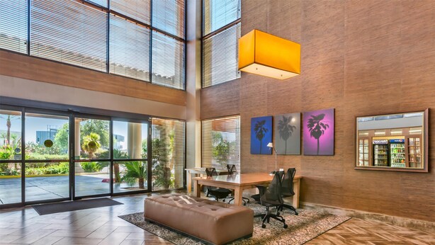 A spacious lobby with a large seating area, a reception desk, and artwork on the walls. - Best Western Plus Scottsdale Thunderbird Suites (Scottsdale)