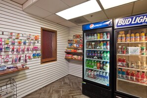 A vending area with Pepsi and Bud Light refrigerators, a display of toiletries, and a wooden counter. - Best Western Plus Scottsdale Thunderbird Suites (Scottsdale)