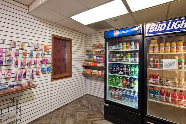 A vending area with Pepsi and Bud Light refrigerators, a display of toiletries, and a wooden counter. - Best Western Plus Scottsdale Thunderbird Suites (Scottsdale)
