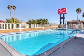 Una piscina al aire libre, tumbonas