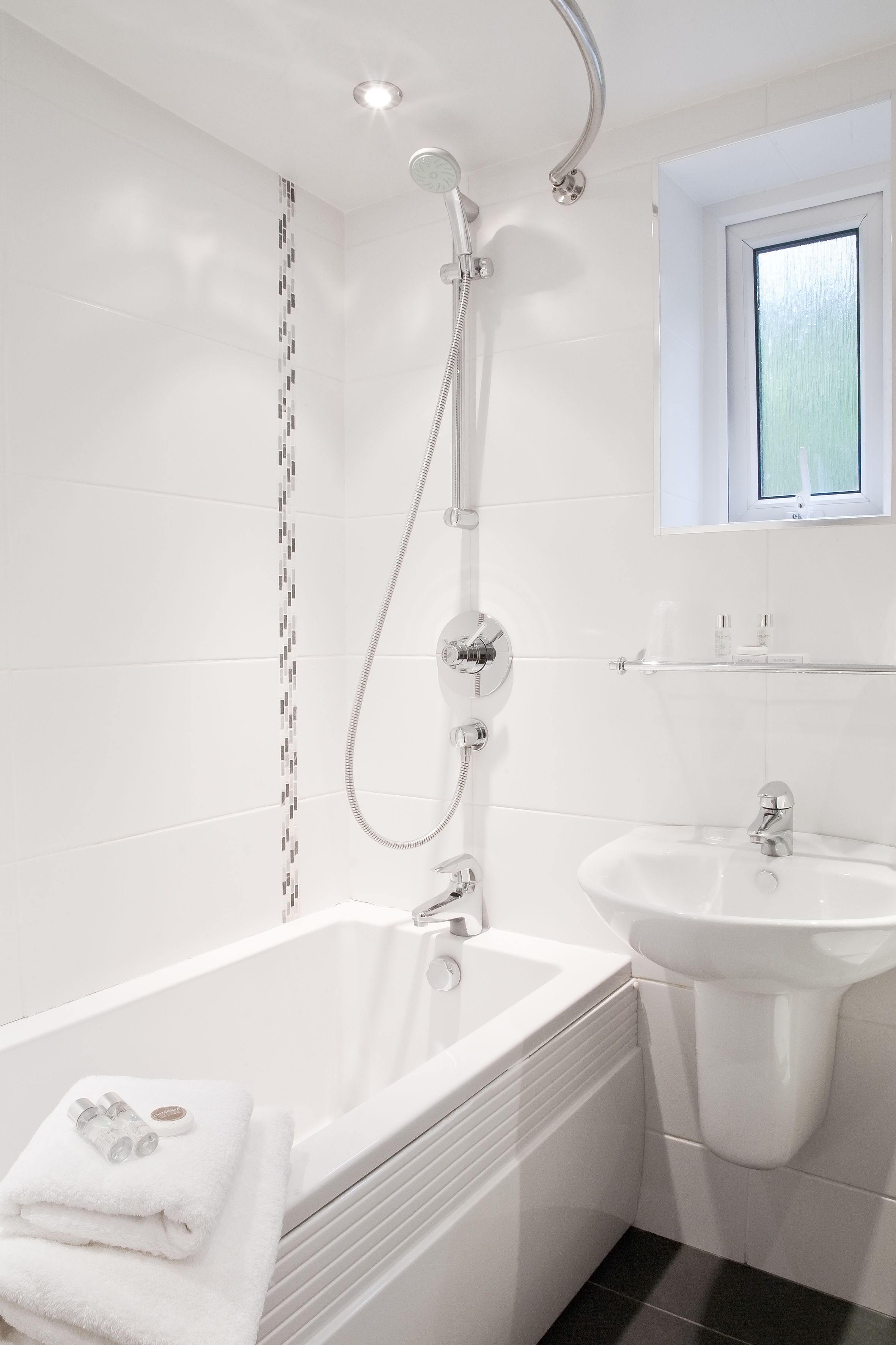 A modern bathroom with a bathtub, a shower, and a sink.