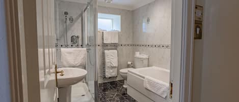 Un baño moderno con ducha de vidrio, lavamanos, inodoro y bañera.